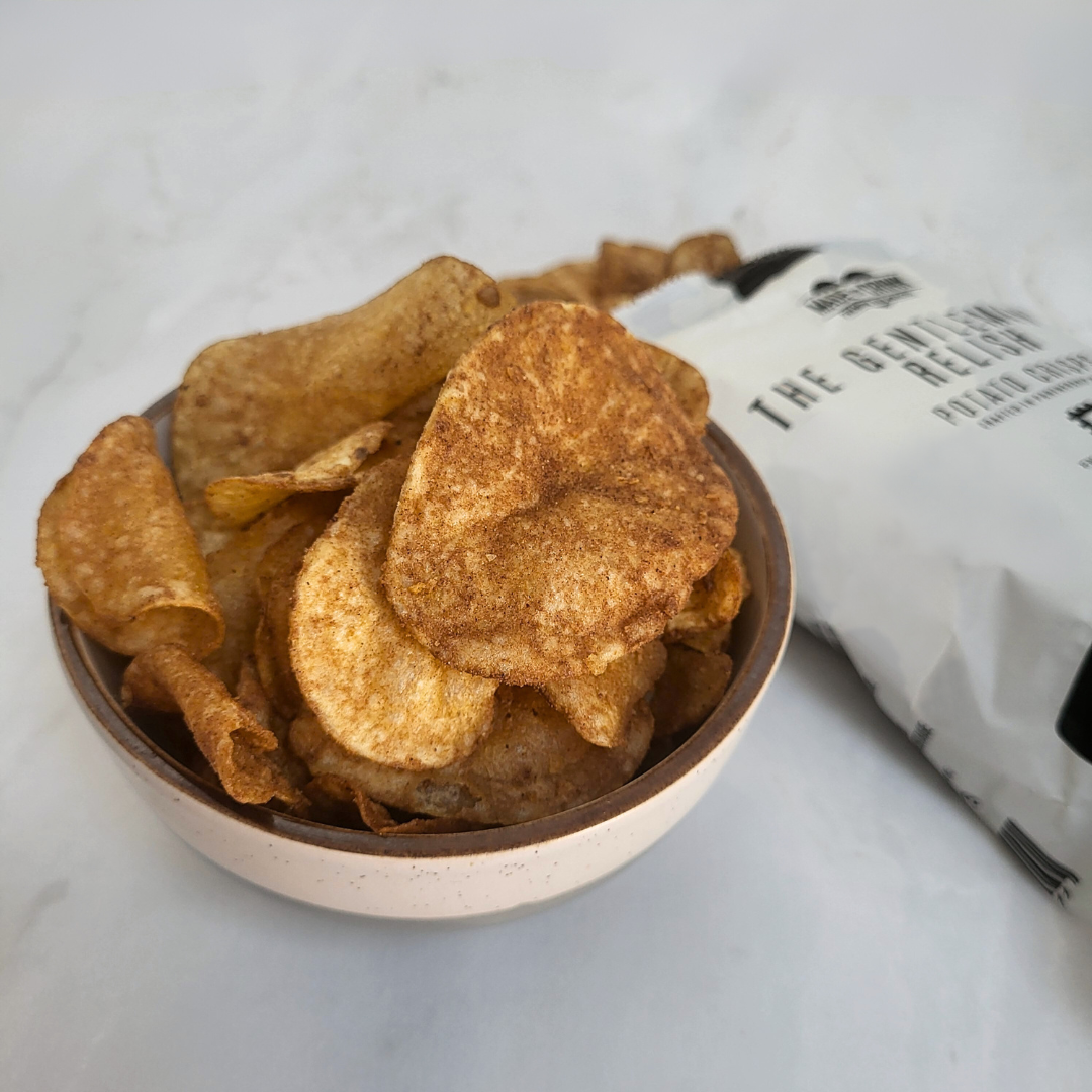 A bowl of Made For Drink's The Gentleman's Relish potato crisps with an open pack in the background.